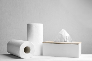 Rolls of paper towels and tissues on white table