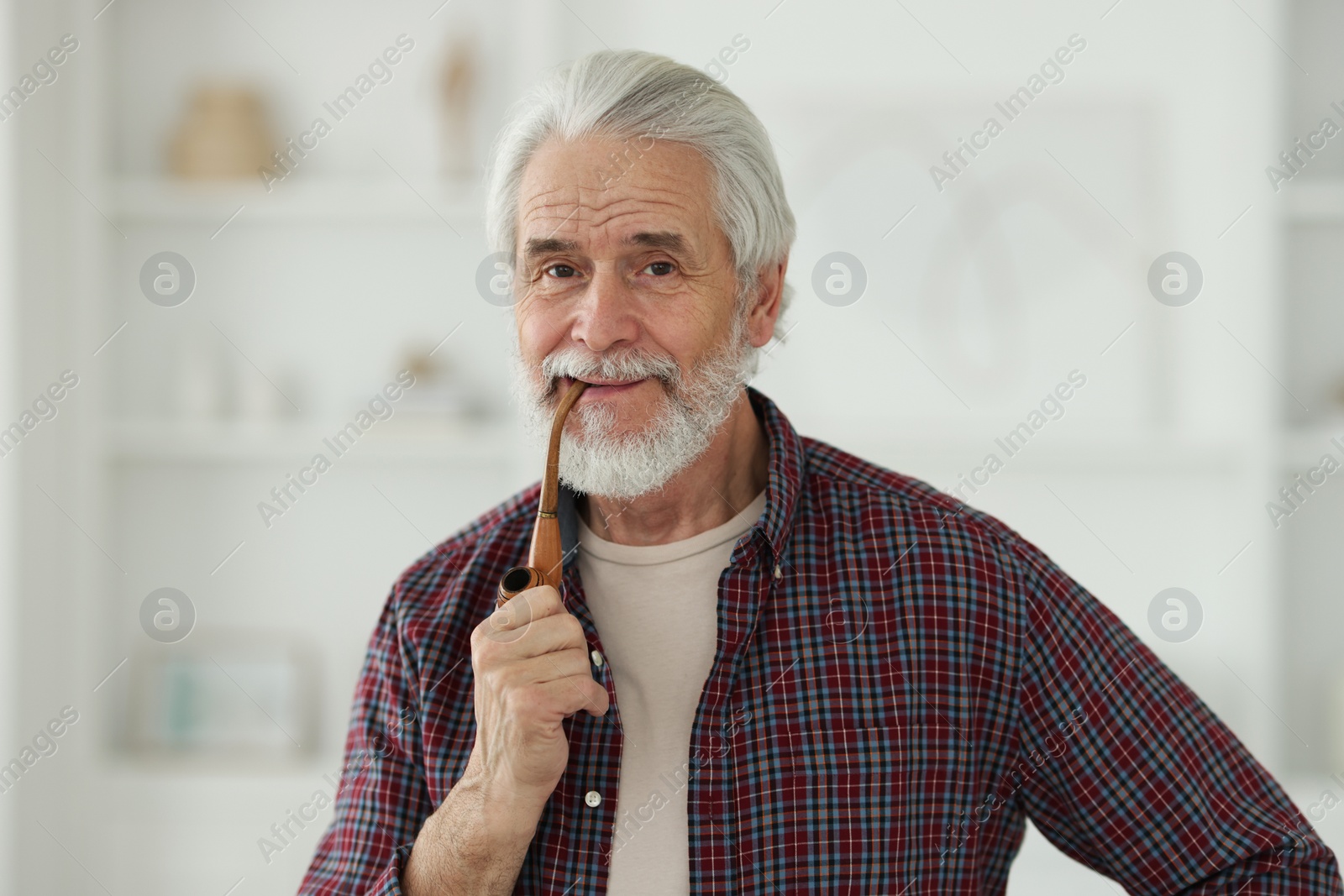 Photo of Portrait of happy grandpa with smoking pipe indoors