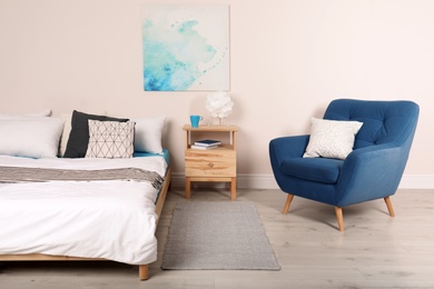 Modern bedroom interior with comfortable armchair. Stylish design