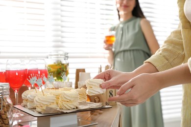 Photo of Woman taking delicious zephyr at baby shower party, closeup