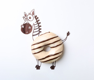 Photo of Funny zebra made with donut on white background, top view