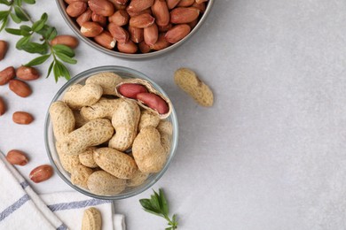 Fresh unpeeled peanuts and leaves on grey table, flat lay. Space for text