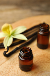 Photo of Aromatic homemade vanilla extract on wooden table, closeup