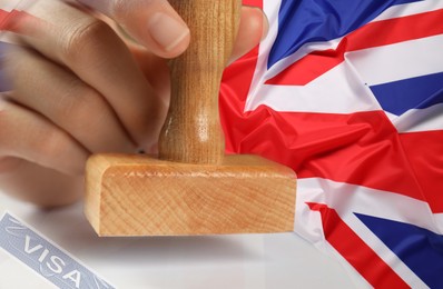 Image of Multiple exposure of woman stamping visa document and flag of Great Britain, closeup