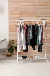 Dressing room interior with stylish clothes on wardrobe rack
