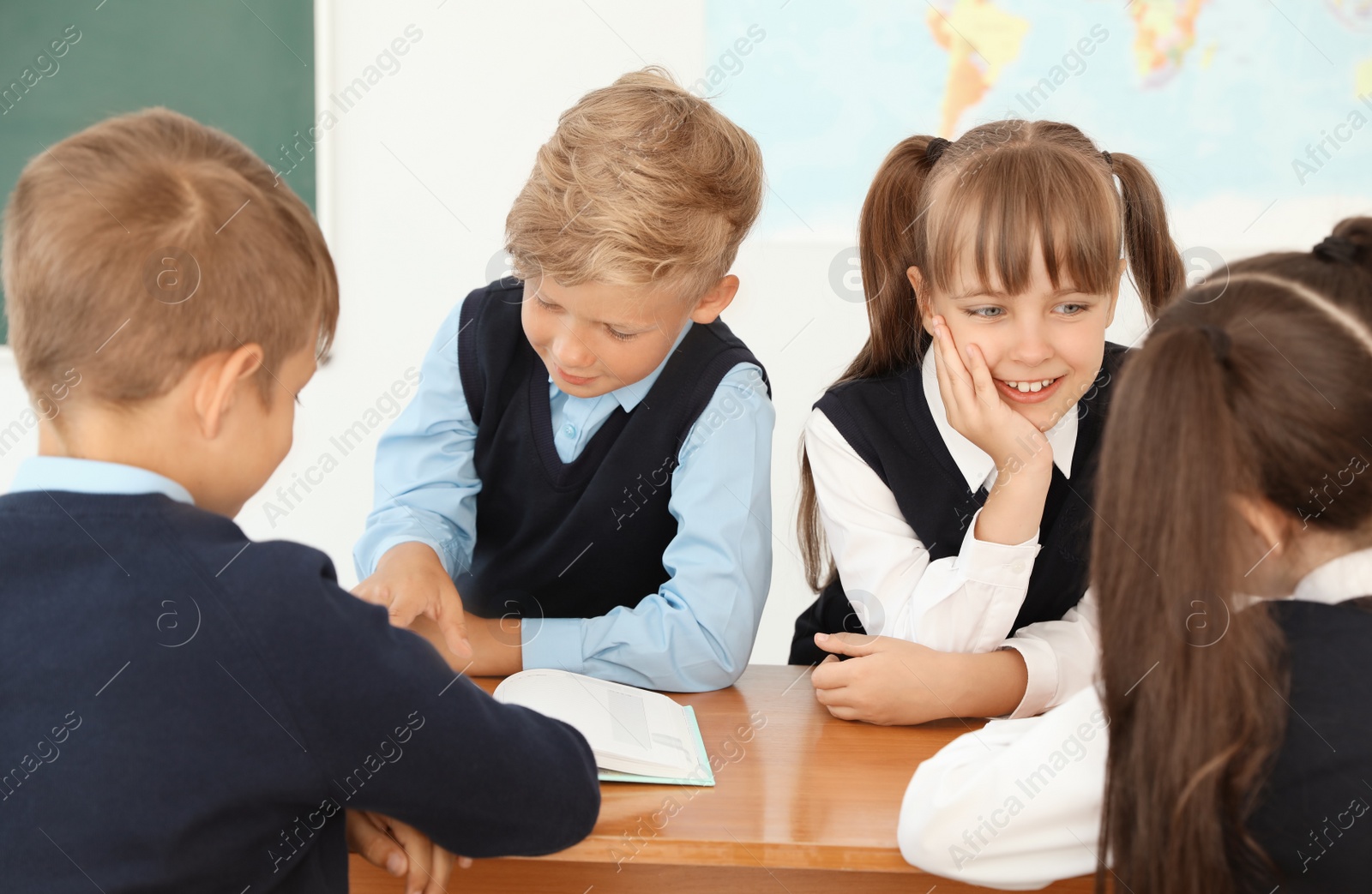 Photo of Little children in classroom. Stylish school uniform