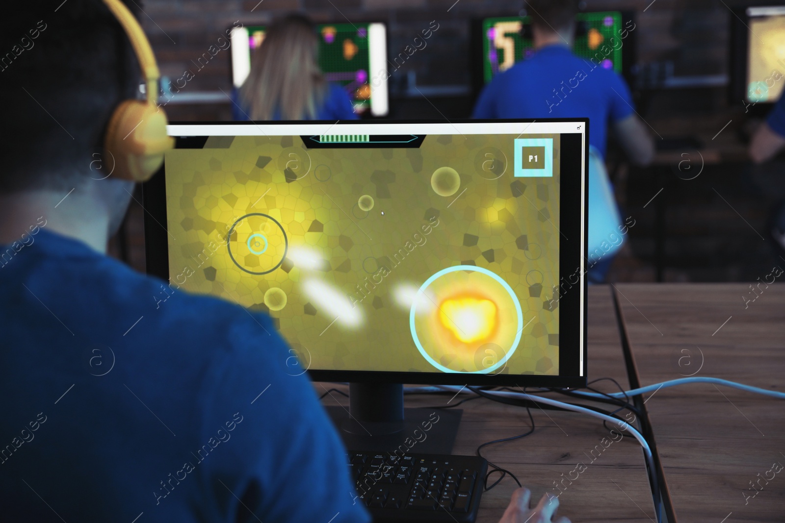 Photo of Man playing video game in internet cafe
