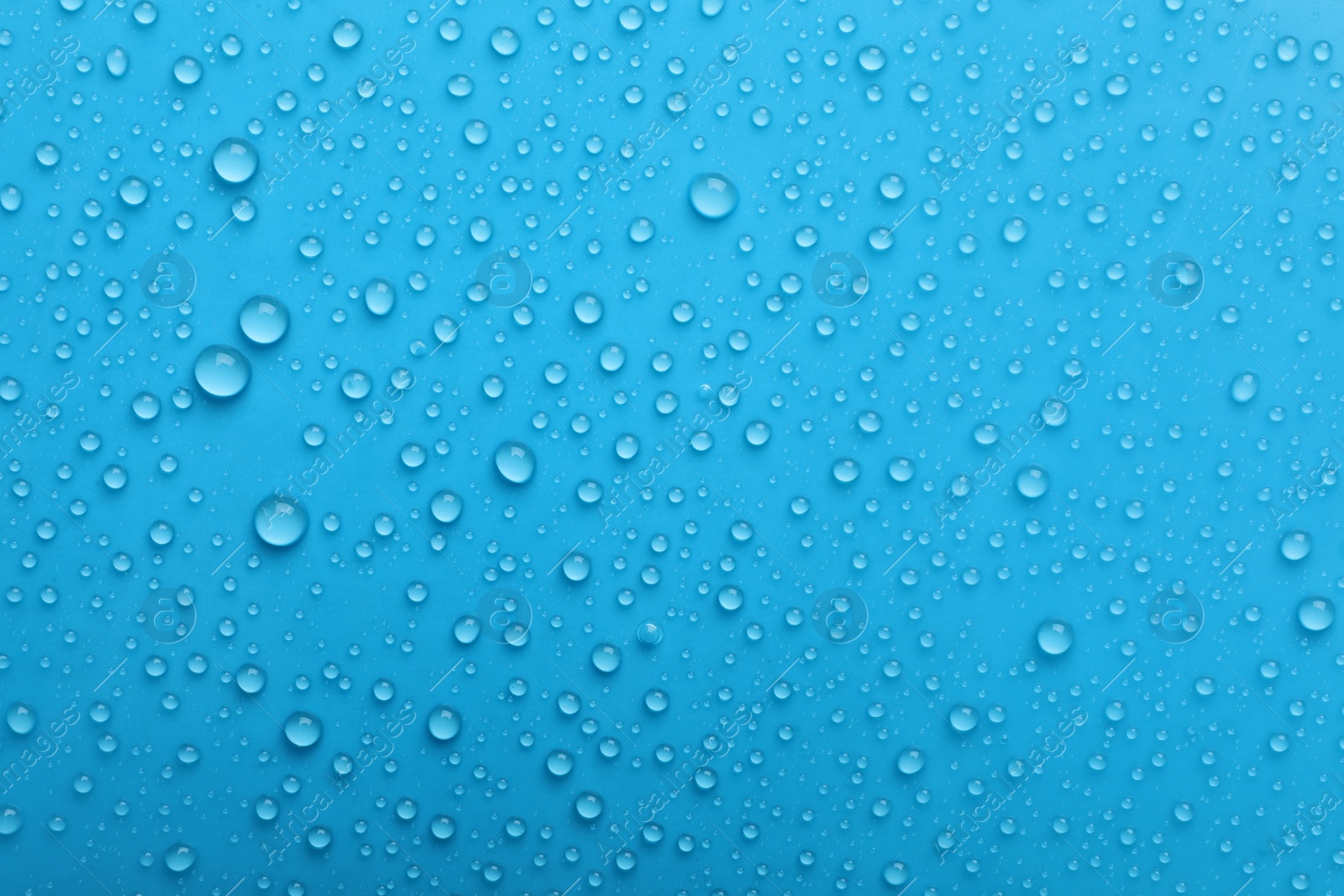 Photo of Water drops on light blue background, top view