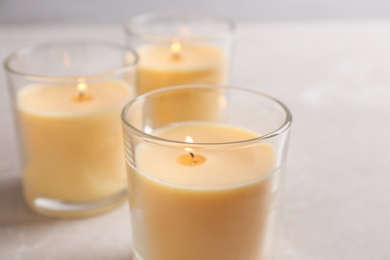 Photo of Three burning candles in glasses on table