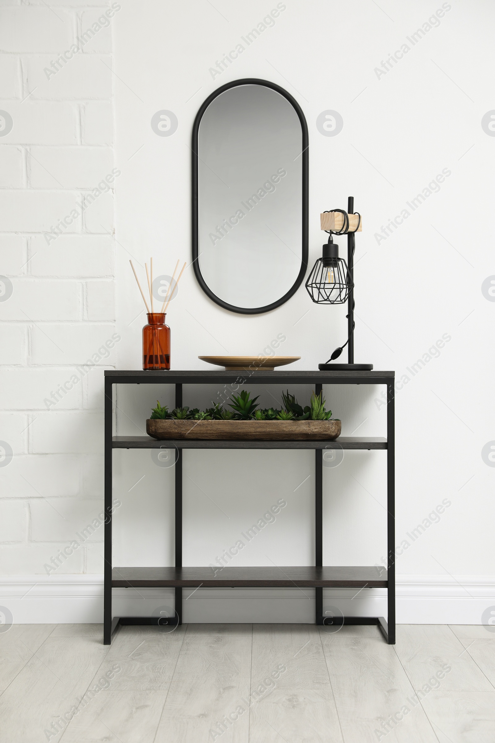 Photo of Console table with decor near mirror in room. Interior design