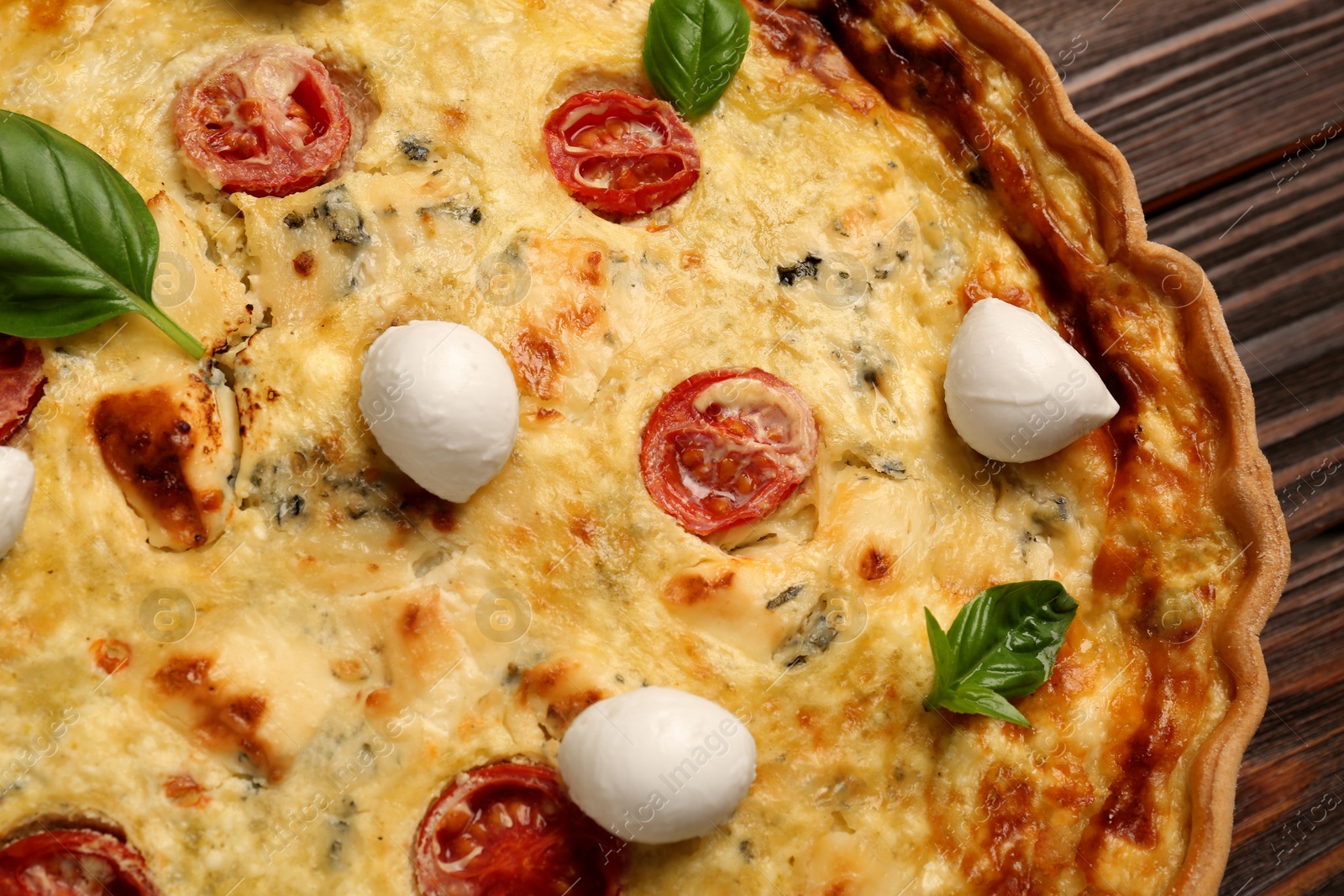 Photo of Delicious quiche with mozzarella cheese, tomatoes and basil, closeup