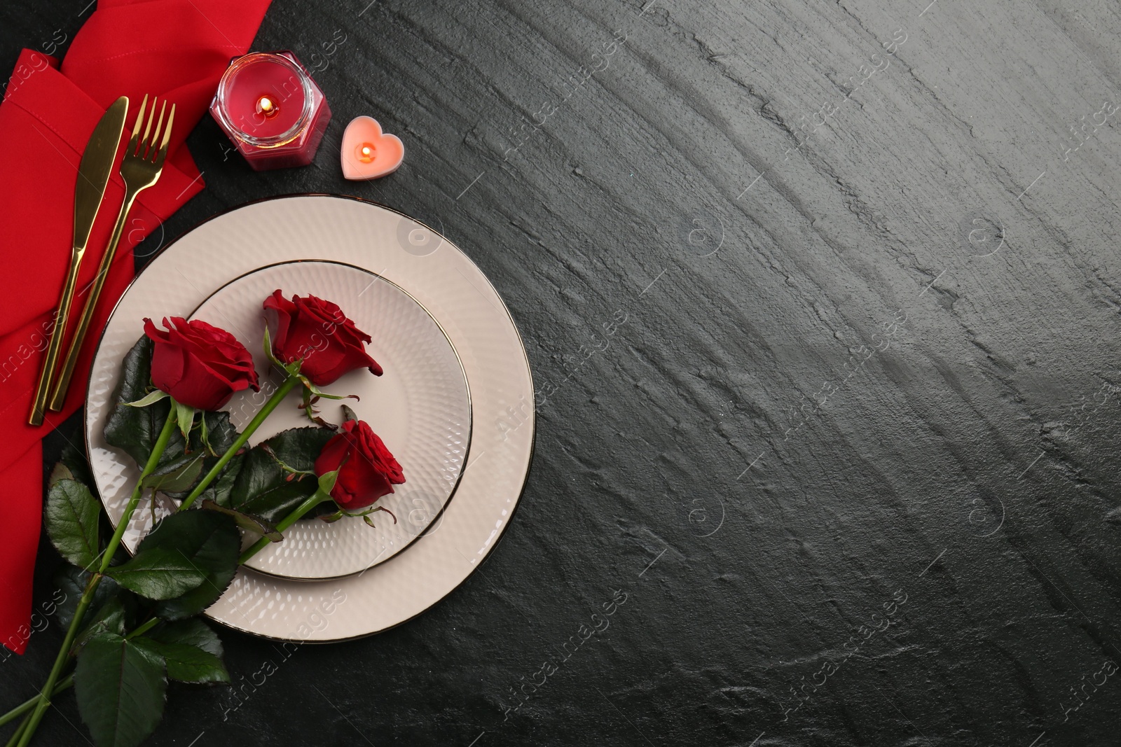 Photo of Place setting with candles and roses for romantic dinner on grey textured table, flat lay. Space for text