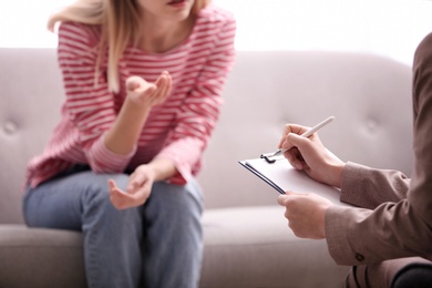 Photo of Psychotherapist working with woman in office, closeup