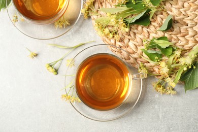 Photo of Flat lay composition with tasty tea and linden blossom on light grey table