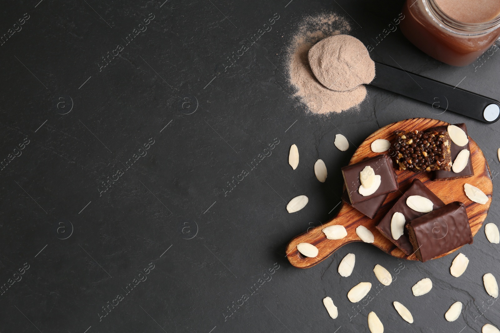 Photo of Different energy bars, almond flakes, protein cocktail and powder on black table, flat lay. Space for text