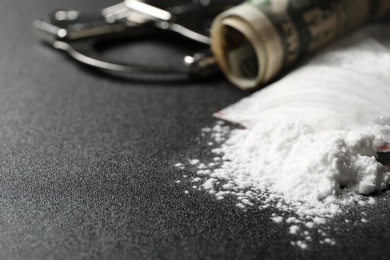 Photo of Cocaine in plastic bag and money on dark background, closeup. Space for text