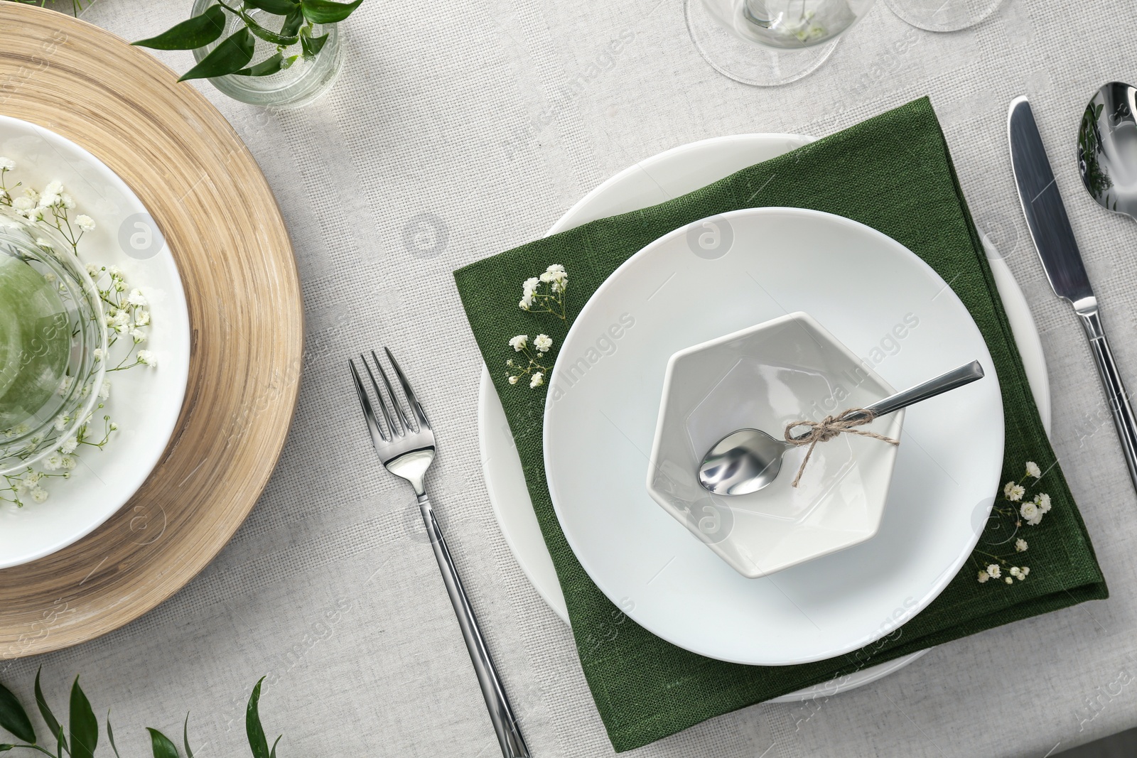 Photo of Elegant table setting with green plants on light cloth, flat lay