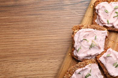 Photo of Tasty sandwiches with cream cheese and thyme on wooden table, flat lay. Space for text