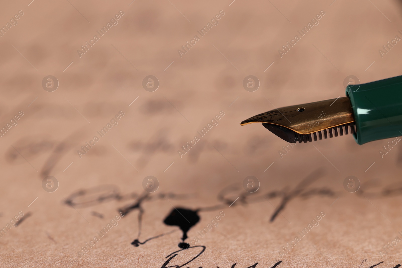 Photo of Elegant fountain pen on handwritten letter, closeup