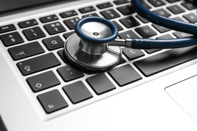 Photo of Stethoscope on laptop, closeup. Concept of technical support