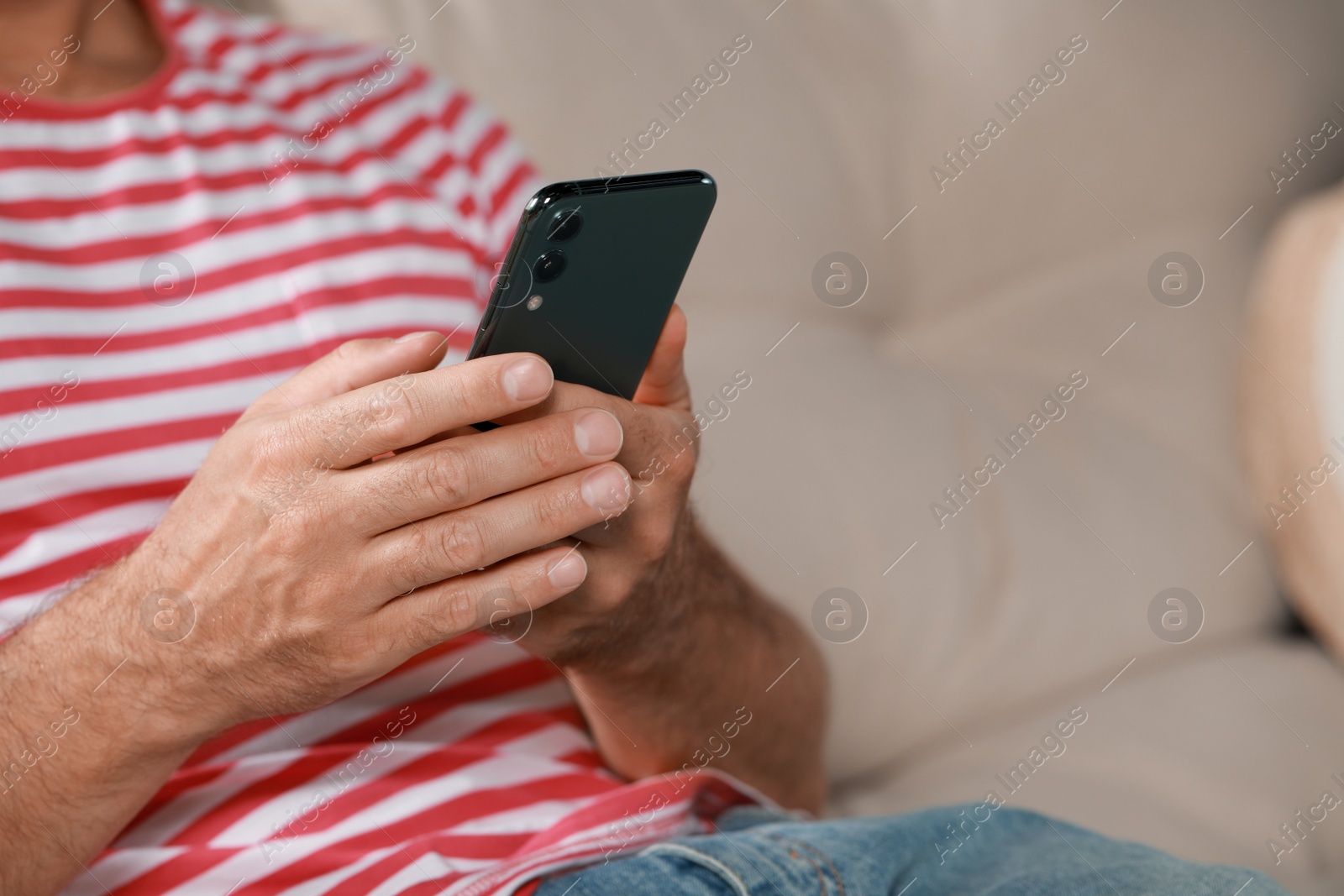 Photo of Man using smartphone at home, closeup view. Space for text