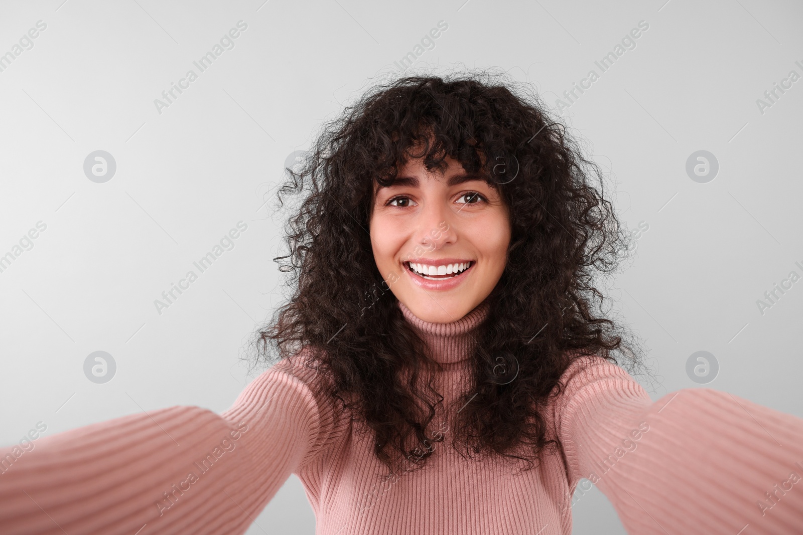 Photo of Beautiful young woman taking selfie on light grey background