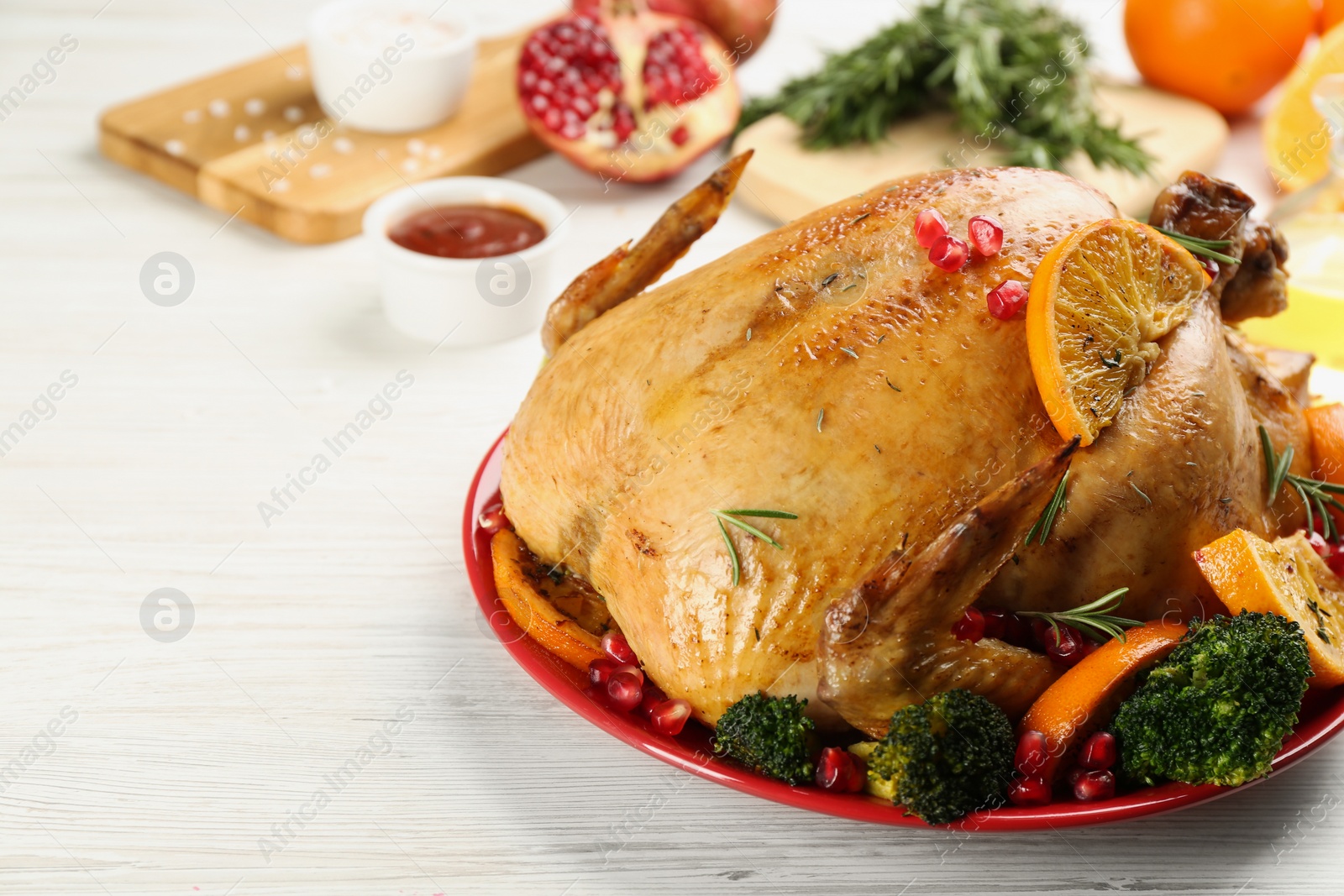 Photo of Delicious chicken with oranges and vegetables on white wooden table