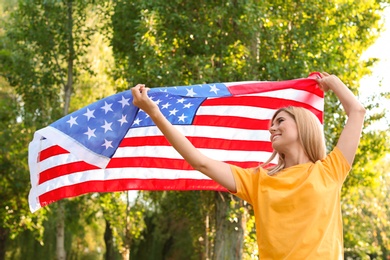 Photo of Woman with American flag in park on sunny day