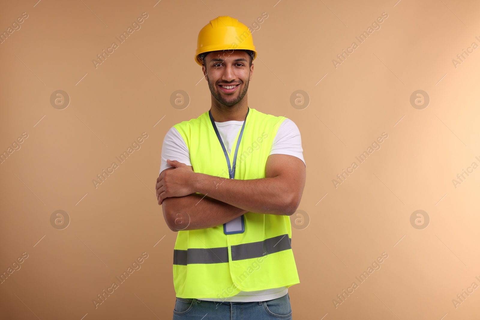 Photo of Engineer with hard hat and badge on beige background