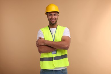 Engineer with hard hat and badge on beige background