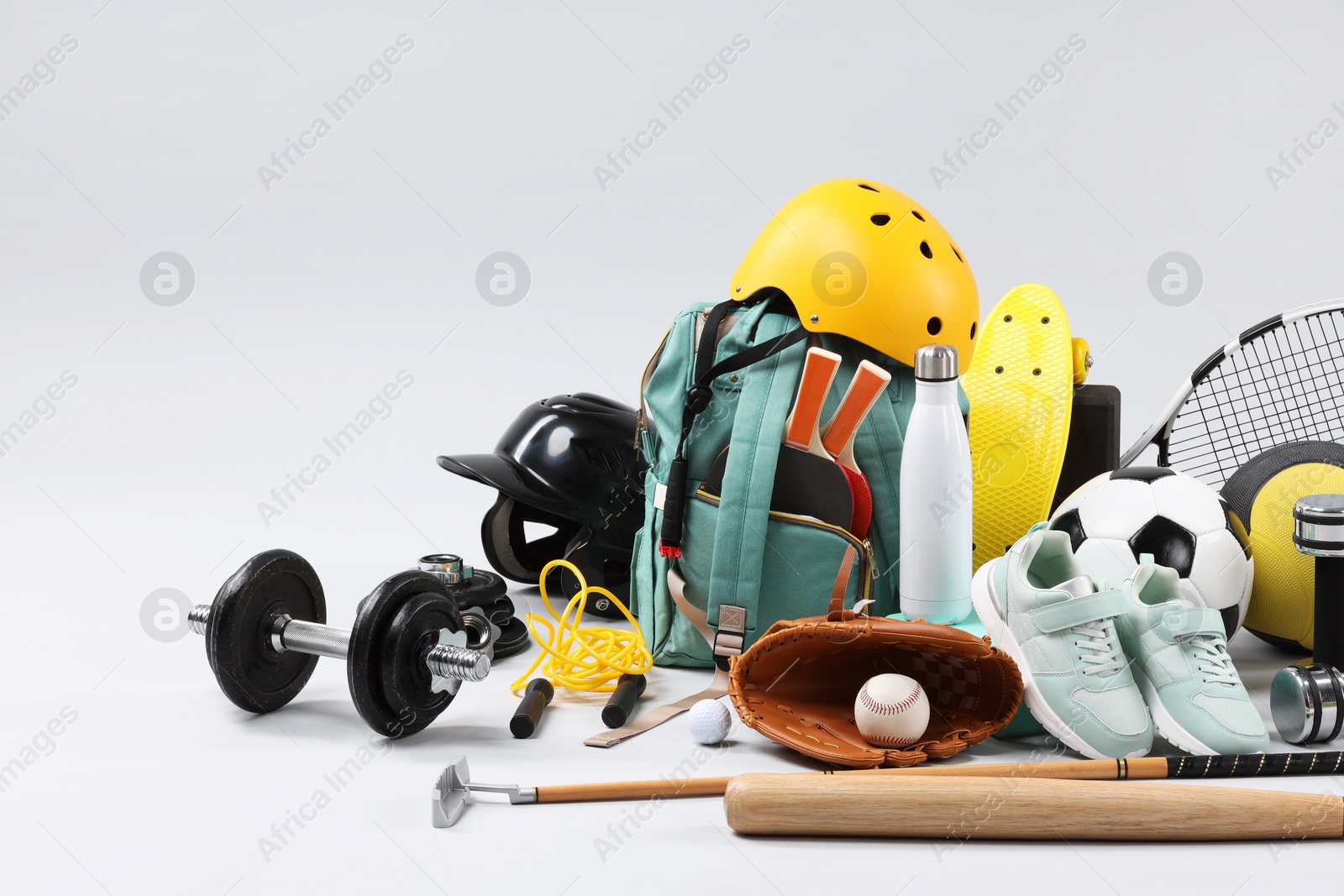 Photo of Many different sports equipment on light grey background