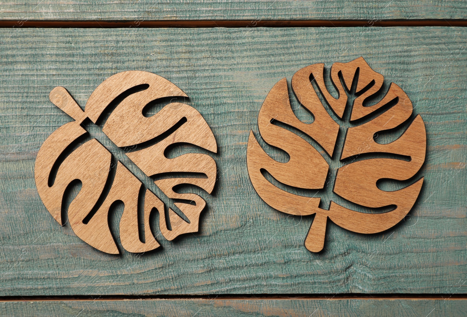 Photo of Leaf shaped cup coasters on blue wooden table, flat lay
