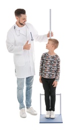 Photo of Doctor measuring little boy's height on white background