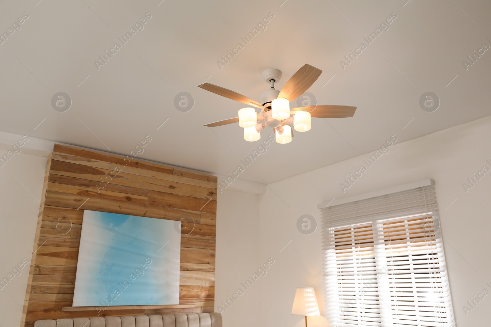 Photo of Modern ceiling fan with lamps in room, low angle view