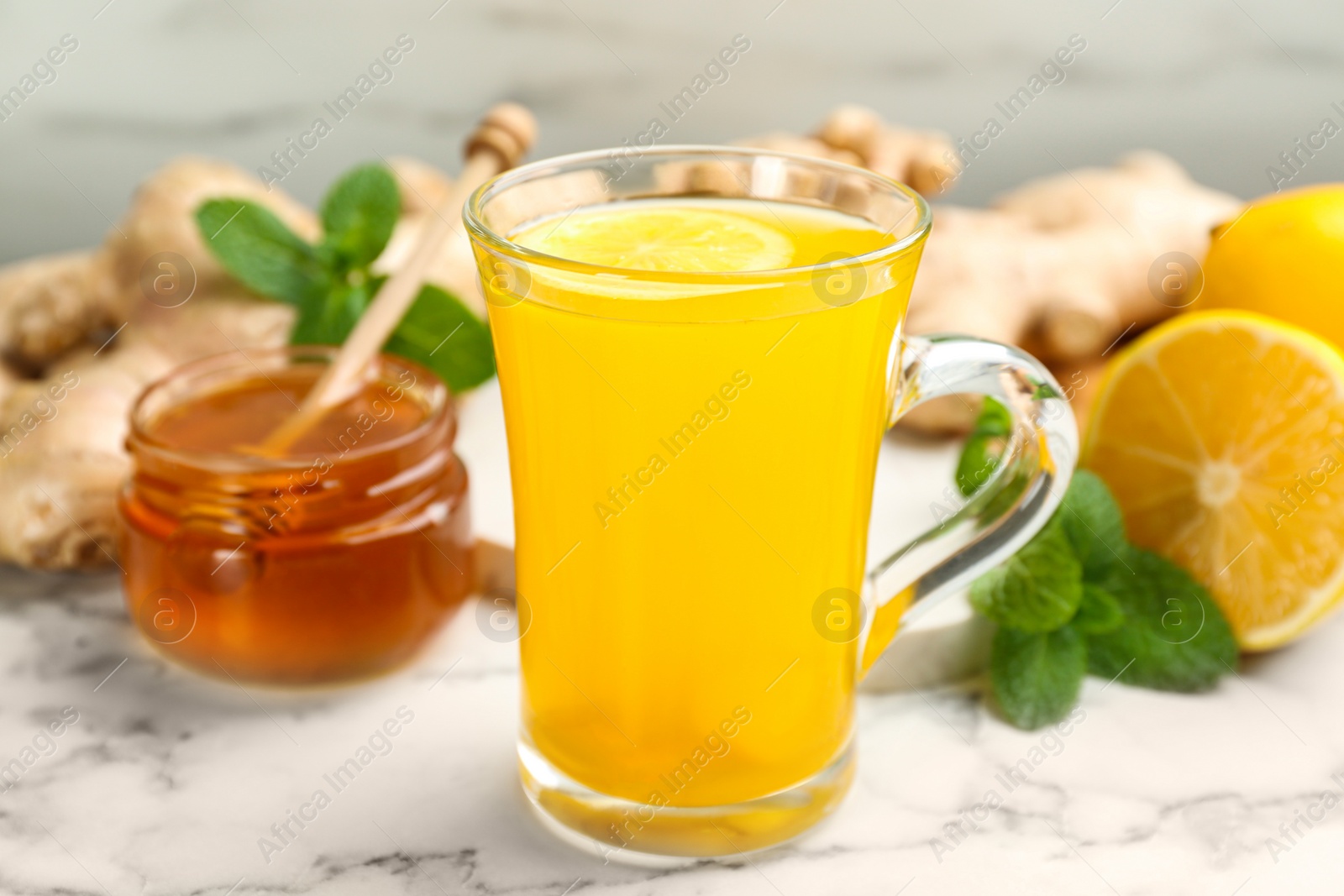 Photo of Immunity boosting drink and ingredients on white marble table, closeup