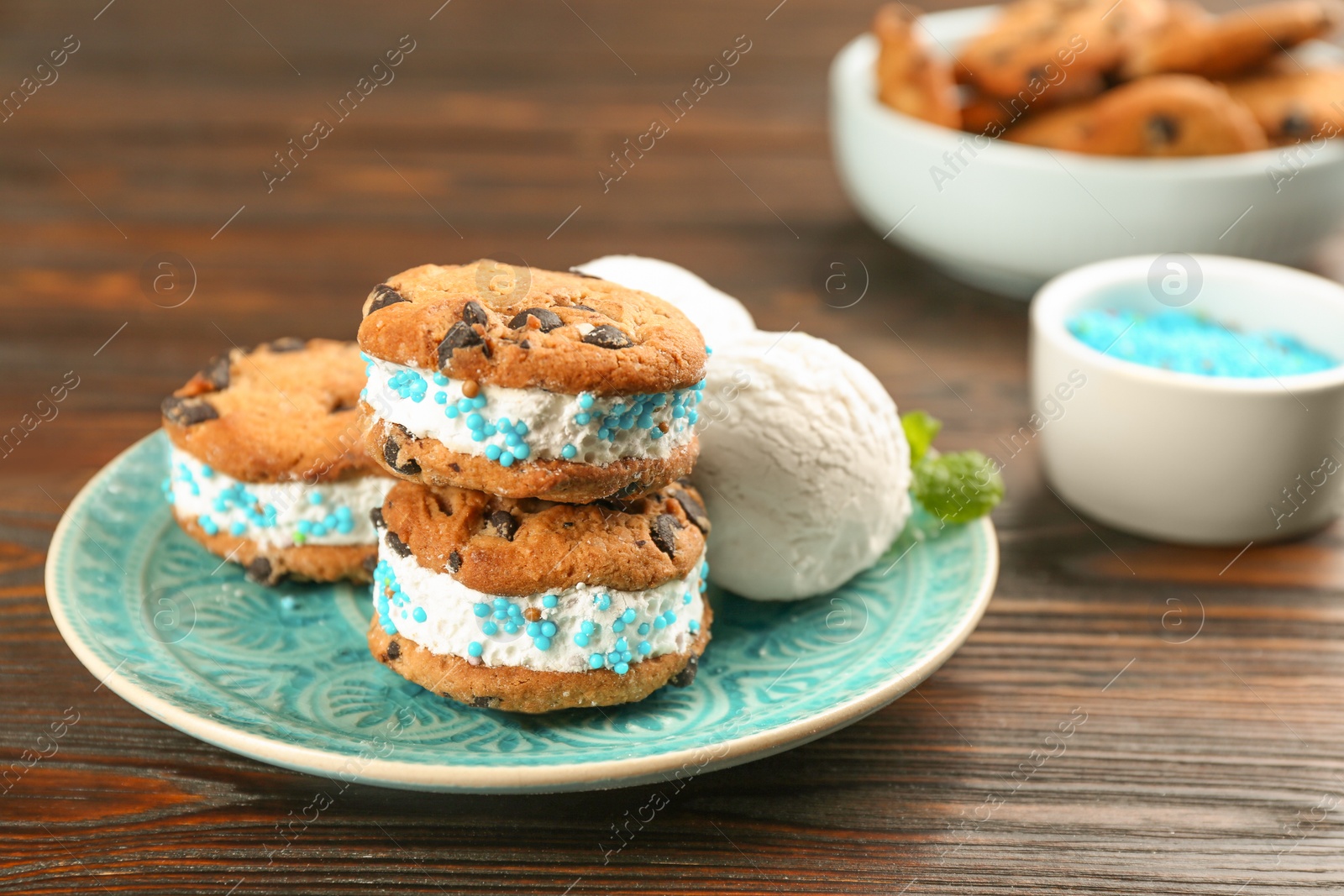 Photo of Sweet delicious ice cream cookie sandwiches on wooden table