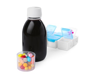 Photo of Bottle of syrup, measuring cup with pills on white background. Cough and cold medicine