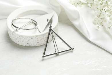 Photo of Beautiful silver hair clips and flowers on white table