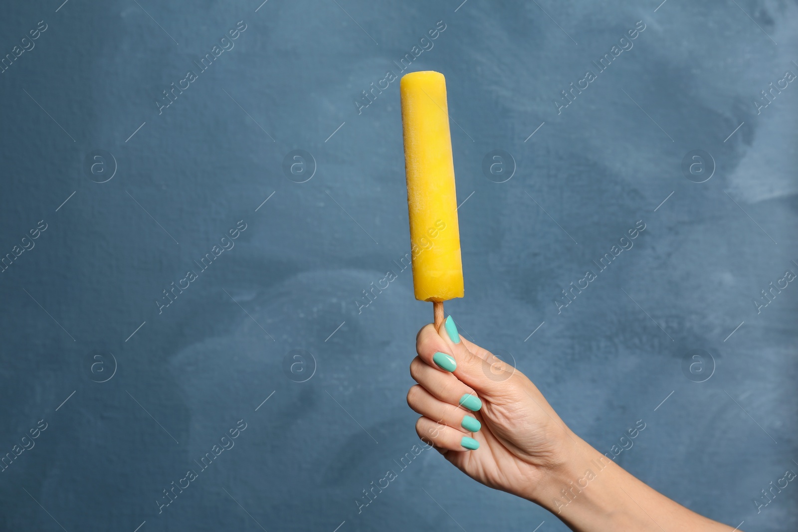 Photo of Woman holding yummy ice cream on color background. Focus on hand