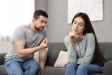 Offended wife ignoring her husband indoors. Relationship problems