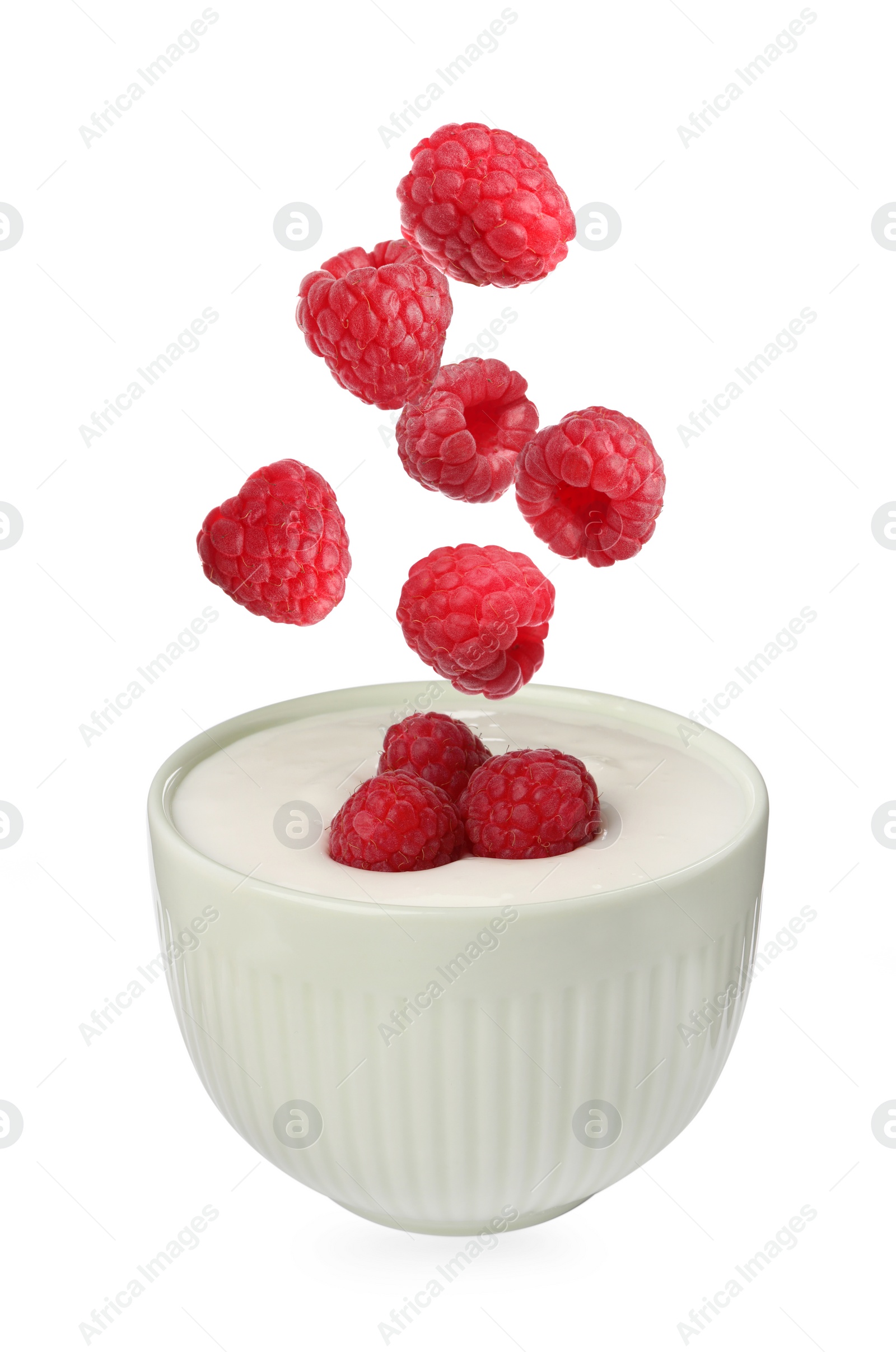 Image of Delicious ripe raspberries falling into bowl with yogurt on white background