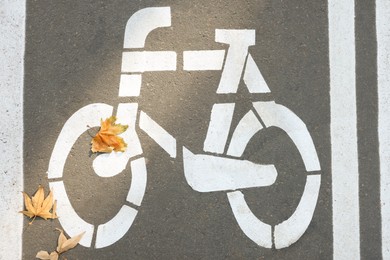 Photo of Bicycle lane with white sign painted on asphalt, top view