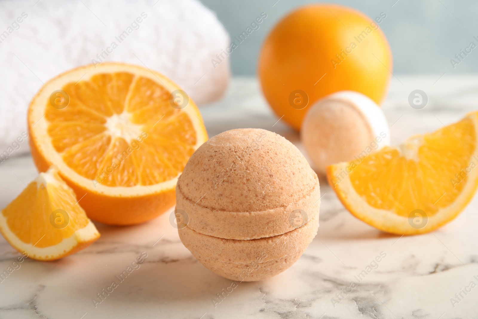 Photo of Bath bomb and orange slices on marble table