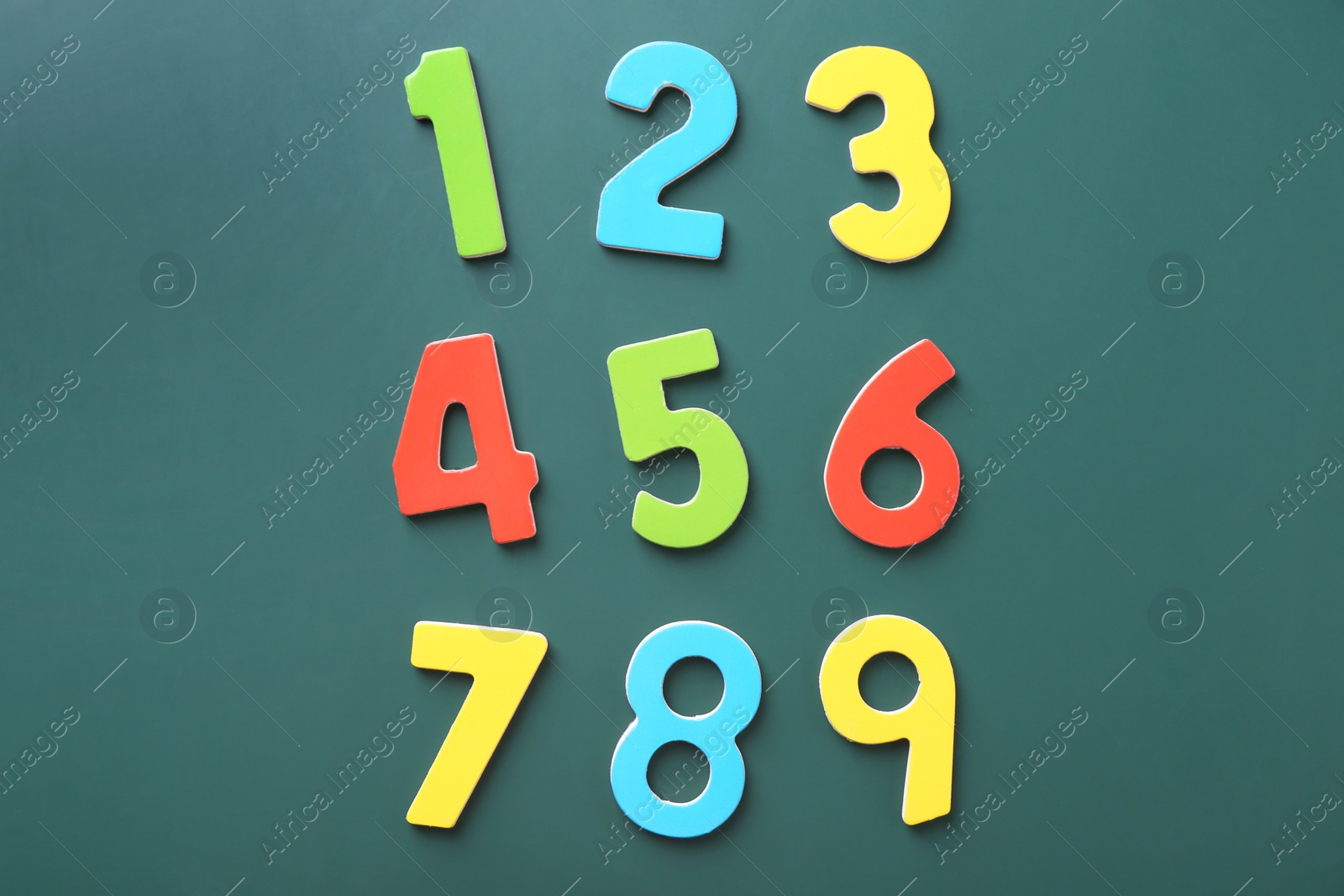 Photo of Colorful numbers on green background, flat lay