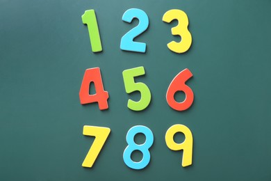 Photo of Colorful numbers on green background, flat lay