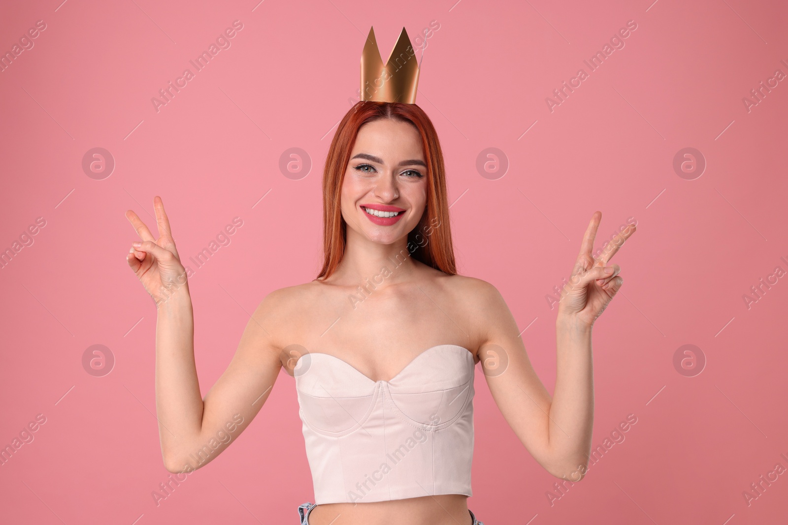 Photo of Beautiful young woman with princess crown on pink background