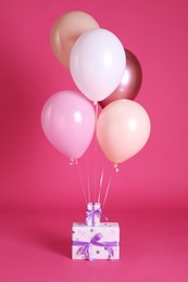 Photo of Gift boxes and balloons near bright pink ​background