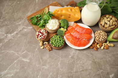 Photo of Different products rich in protein on marble table
