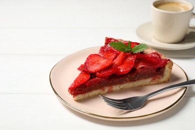 Photo of Piece of delicious strawberry tart with mint on white wooden table, closeup. Space for text
