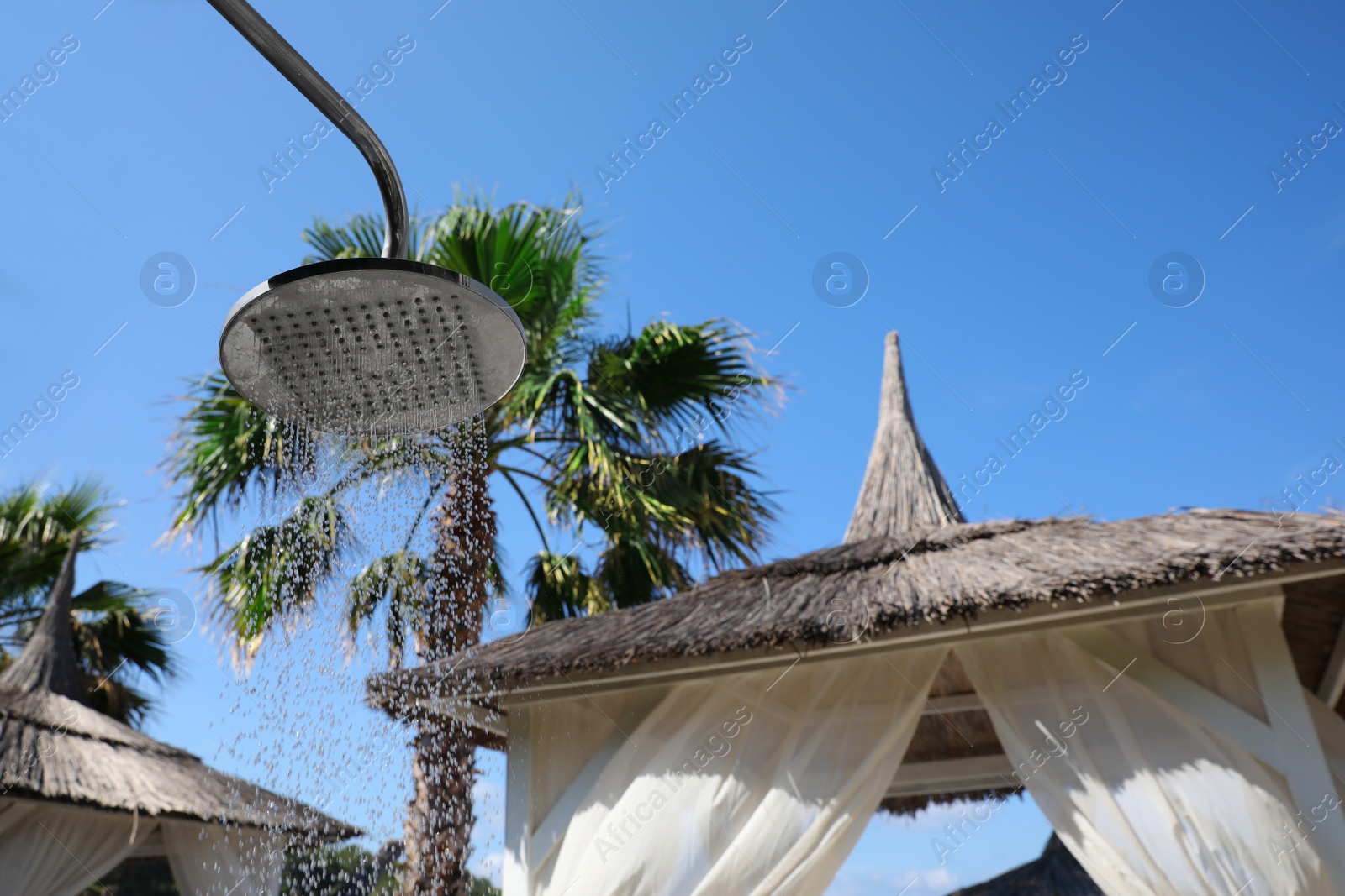 Photo of Outdoor shower with running water on beach at resort